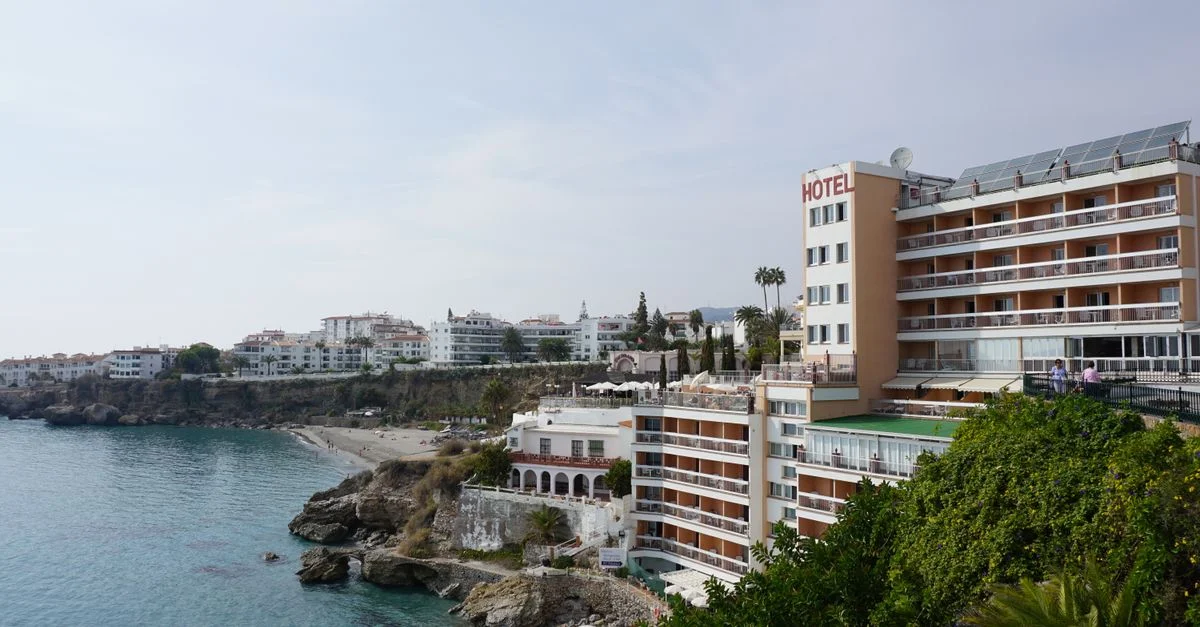 Hôtel élégant sur une côte rocheuse avec vue sur la plage et l'océan.