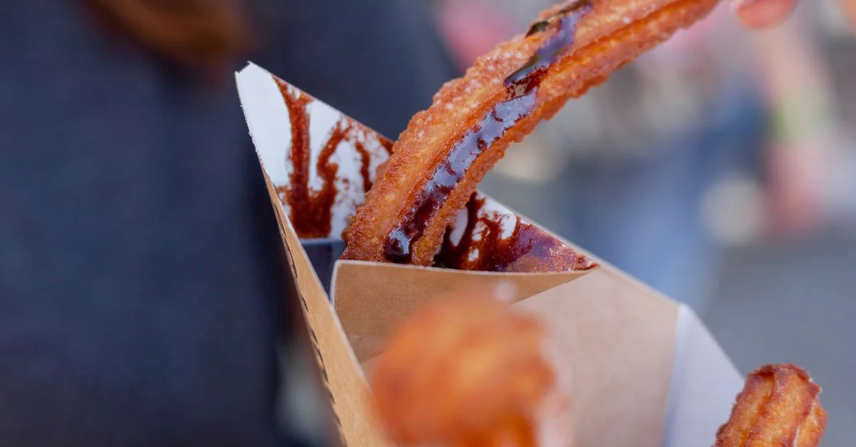 Délicieux churros avec du sirop de chocolat, capturés dans un gros plan de photographie alimentaire.