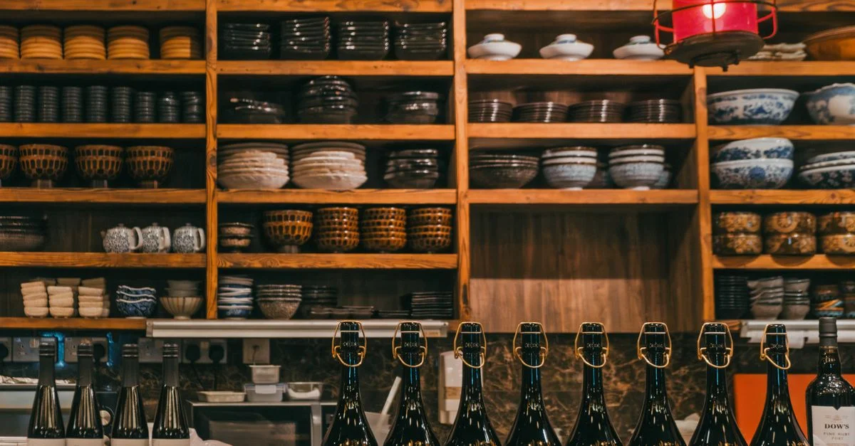 Charmante cuisine rustique avec des étagères soigneusement disposées et des bouteilles élégantes sur le comptoir.
