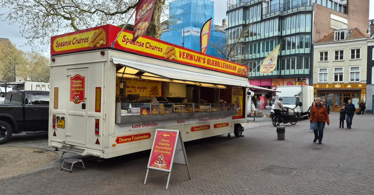 Un camion de cuisine de rue coloré à Utrecht vend des churros et des oliebollen sur une place animée de la ville.