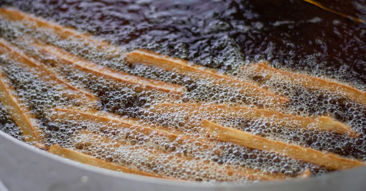Gros plan de frites en train de frémir dans de l'huile chaude. Parfait pour les passionnés de cuisine.